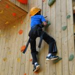 Student on climbing wall during school group team building visit to Wenonah Outdoor Centre in Muskoka Ontario