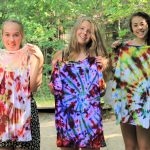 An image of participants holding tie dye shirts